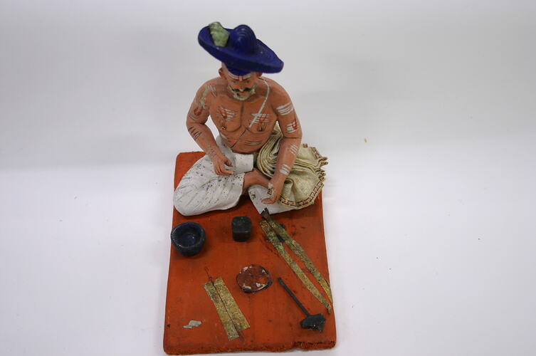 Model: Figure of a man sitting with legs crossed and tools