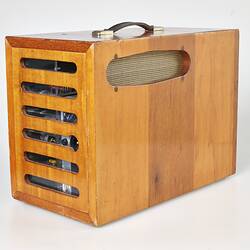 Back view of rectangular wooden box with horizontal slats and handle on top.