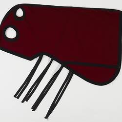 Red and black woollen horse hood. Four straps. Two cut out holes.