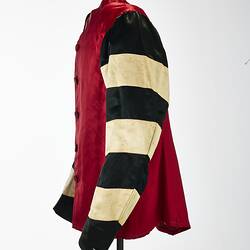 Profile of red riding jacket with red buttons. Black and white hoops on sleeves. Short stand up red collar.