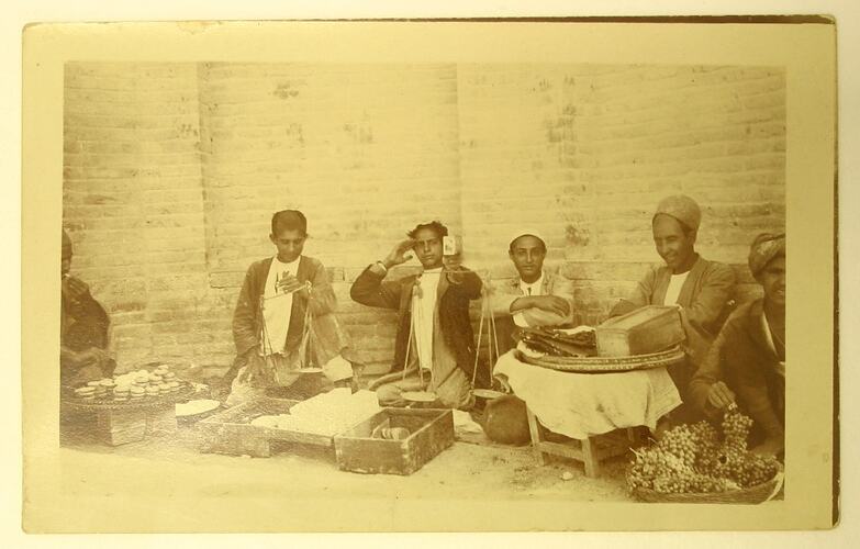 Street sellers sitting on gound with wares.