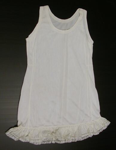 White rayon petticoat lying on black surface.
