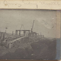 Damaged railway cars, telephone poles in the background.