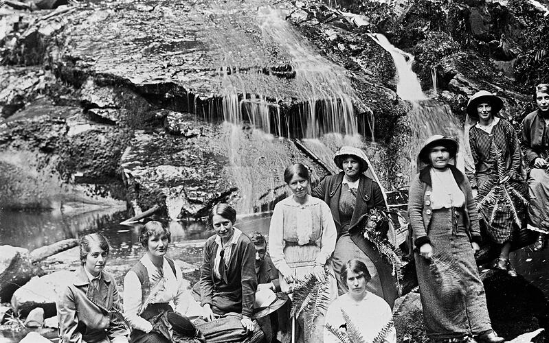 Women in front of waterfall.