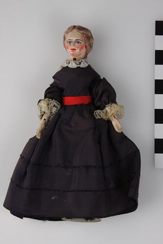 Wooden female doll in dark navy dress.