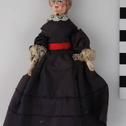 Wooden female doll in dark navy dress.