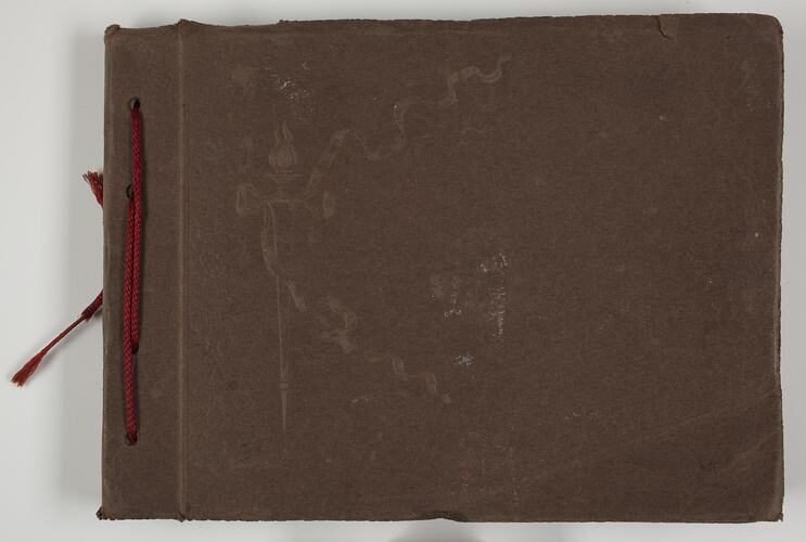Cover of a photograph album held together with red cord.