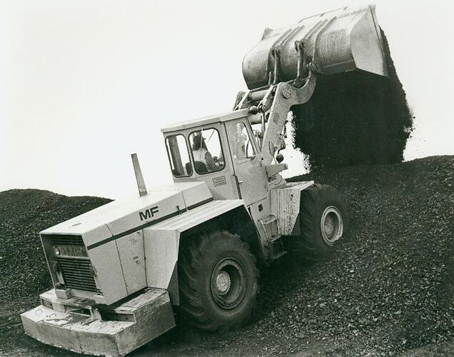 Man operating a front end  loader in a rock pile.