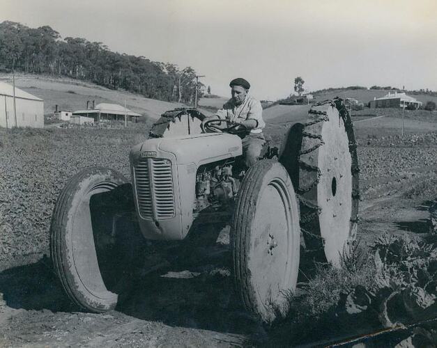 Man driving a tractor fitted with over size wheels.