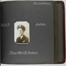 Page with handwritten white text and photograph of servicemen in centre.
