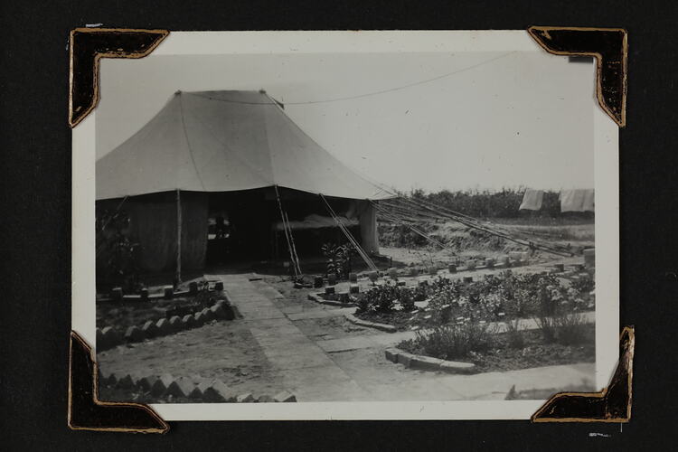 Exterior view of a tent, with garden beds in front.
