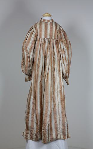 Front view, long dress, cream and tan stripes.