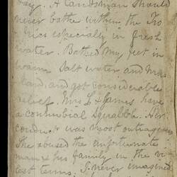 Open diary with handwritten text on discoloured worn page.