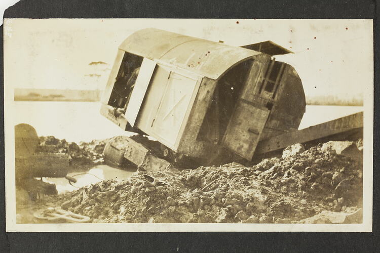 Monochrome photograph of a destroyed excavator.