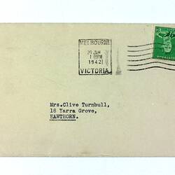 Typed envelope with green stamp and postmark