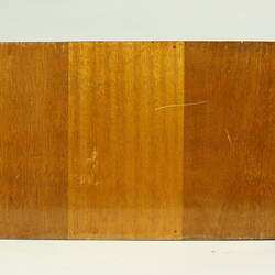Bottom view of wooden box with black rubber foot in each corner.