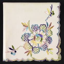 Folded white handkerchief with floral embroidery.