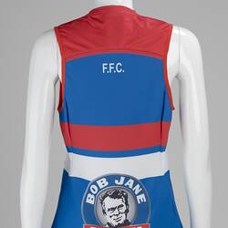 Back of sleeveless blue football jumper with red and white horizontal stripes. Logo also.