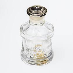Glass carousel shaped perfume bottle, gold plastic lid. Carousel has horses, swans.