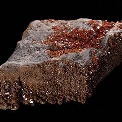 Red-orange crystals on grey rock.