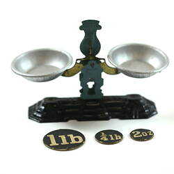 Toy metal scales behind paper circles.