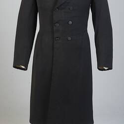 Gentleman's black cotton frock coat, six-button, double-breasted with peaked lapels.