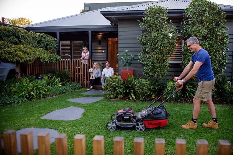 Man mowing lawn at home with family during COVID-19 lockdowns, Northcote, Victoria, date TBC