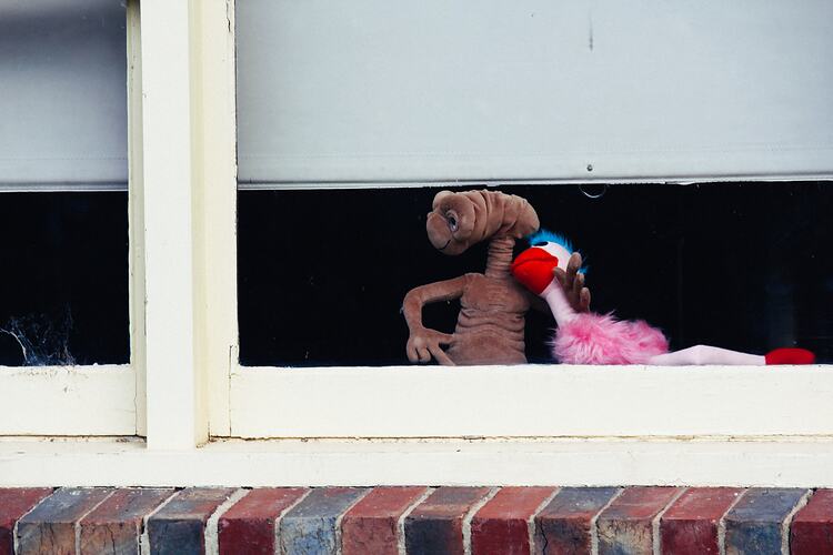 E.T. and Ossie Ostrich toys placed in window.