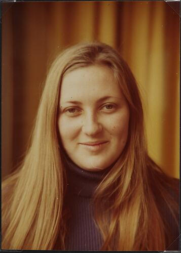 Young woman with long light brown hair smiling.