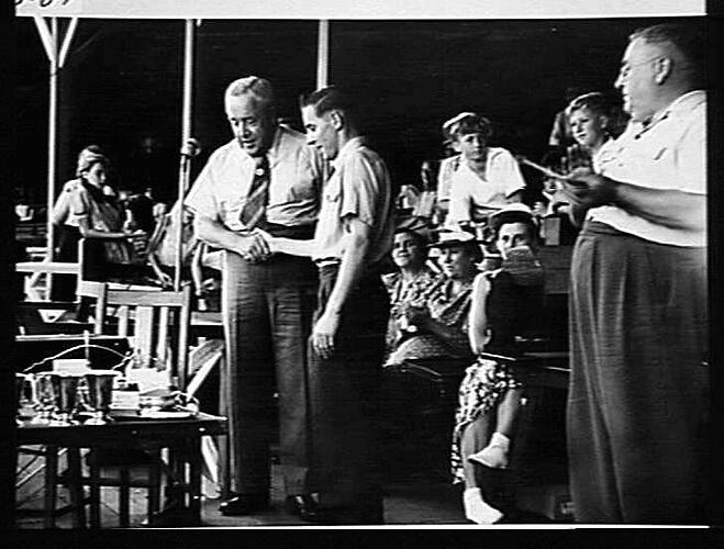 SUNSHINE HARVESTER WORKS PICNIC 1950: HELD AT THE FRANKSTON PARK. MR A.D.J FORSTER, WORKS DIRECTOR, CONGRATULATES HAROLD MASON DURING THE PRESENTATION OF TROPHIES: `SUNSHINE REVIEW': APRIL 1950