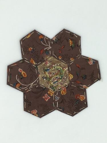 Brown with orange floral hexagonal coloured fabric patches that are stitched together. Brown centre.