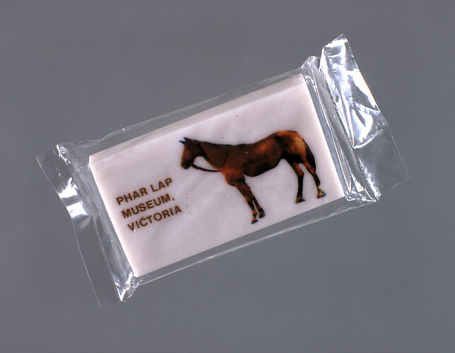 White eraser with picture of horse, brown text.