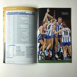 Open football record with text on left page and female footballers contesting on right page.