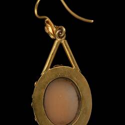 Back of gold mounted cameo earring. Round brown centre, gold border.
