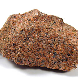 Red and black speckled piece of granite rock.