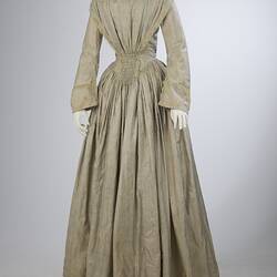 Pale grey striped silk dress with long sleeves and long skirt.