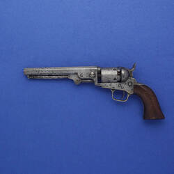 Slightly worn revolver with wooden grip.