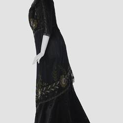 Black, silk satin dress, beading, floral embroidery. Profile.