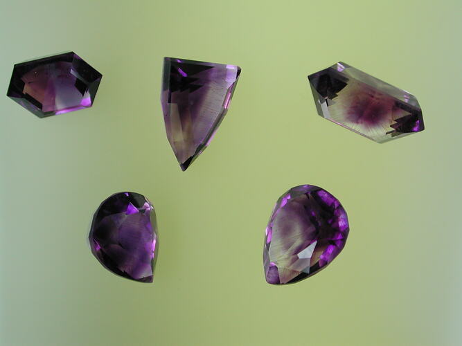 Five faceted purple amethyst specimens.