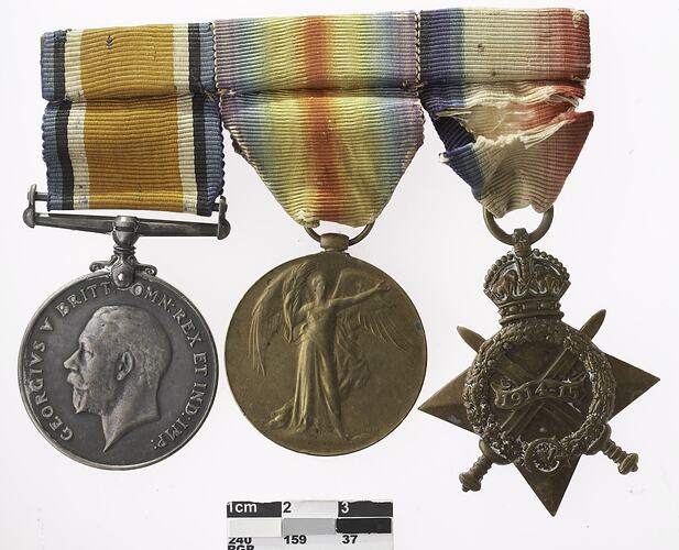 Three joined medals, two round and one four point star shaped, all with multicoloured ribbons attached to top.