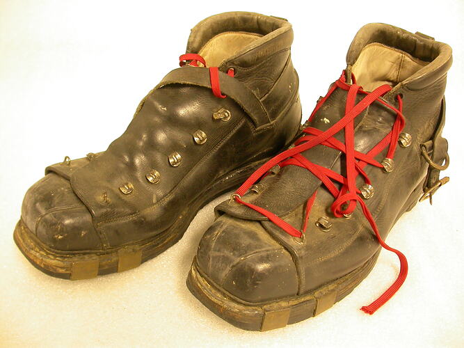 Pair of 1950s brown ski boots with red laces.