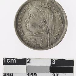Round bronze coloured medal with profile of a crowned woman and text surrounding.