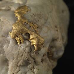 Detail of gold on surface of white rock.