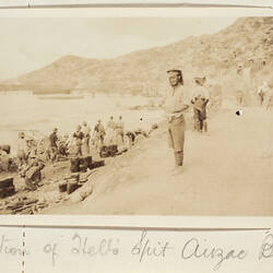 Servicemen on a beach with buckets and carts.