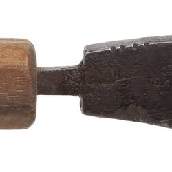 Right view iron tool mounted onto wooden handle.
