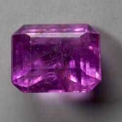 Pink, cut, rectangular gem.