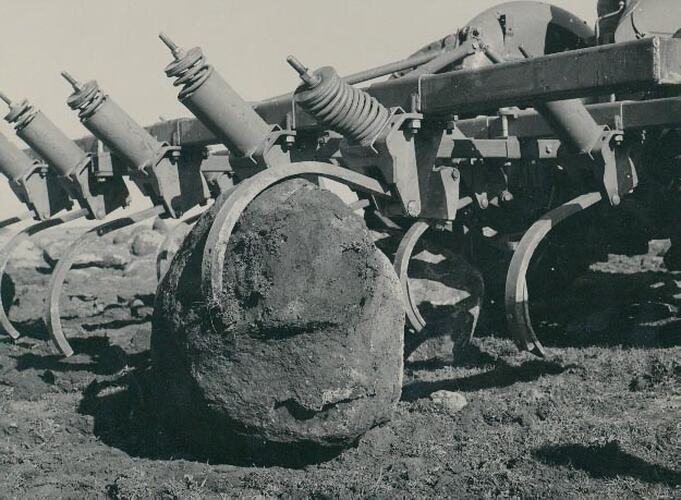 Rear view of a tiller testing the spring release on a big rock.