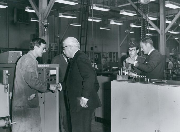 Five men standing in factory workshop.