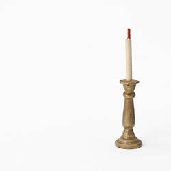 Miniature wooden candlestick and candle.