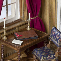 Minature writing desk and chair in dolls house.
